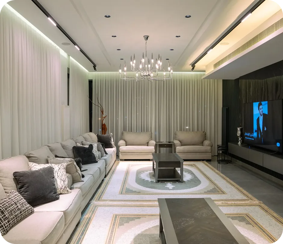 Finished basement living room with sectional sofa, television and chandelier