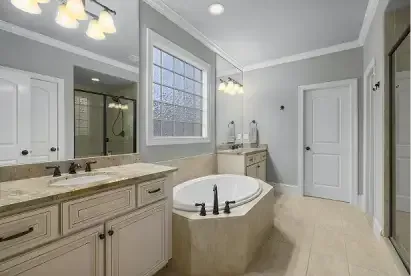 Renovated bathroom with soaking tub and granite vanity